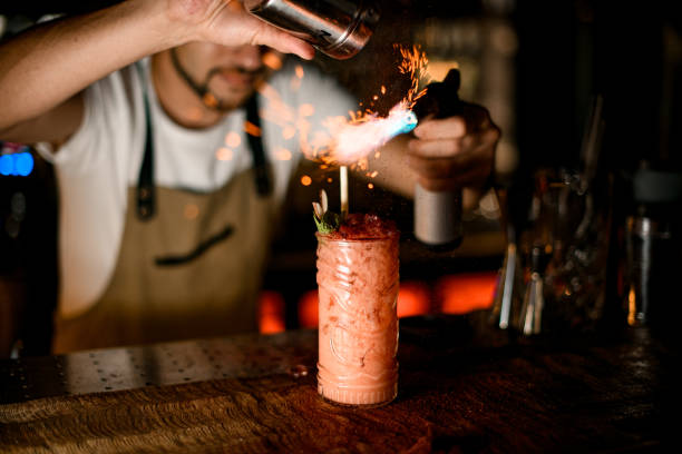 bartender feuert alkoholcocktail mit brenner ab - ready to cook flash stock-fotos und bilder