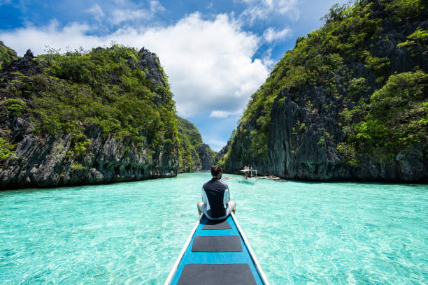 el nido, palawan, philippines, traveler on boat exploring the natural sights around el nido on a sunny day - palawan photos et images de collection