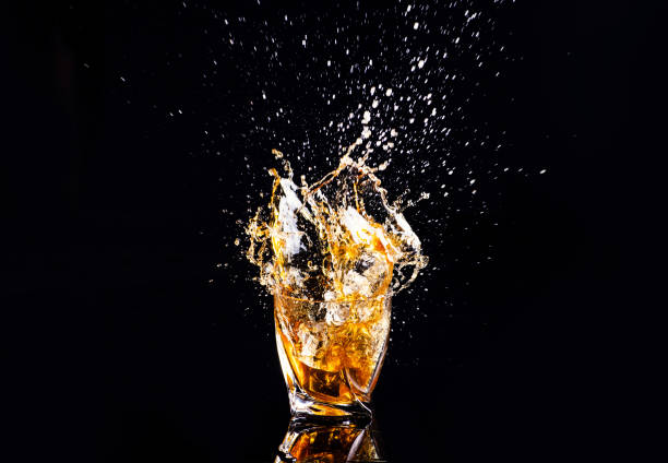 istock whiskey with splash on black background, brandy in a glass 1189227780