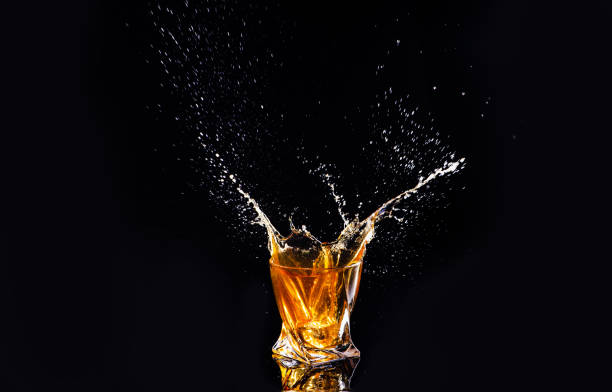 istock whiskey with splash on black background, brandy in a glass 1189227793