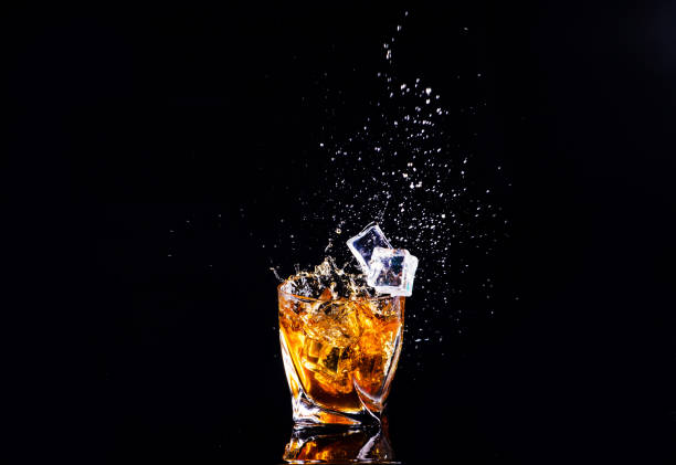 istock whiskey with splash on black background, brandy in a glass 1189227801