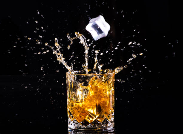 istock whiskey with splash on black background, brandy in a glass 1189230090