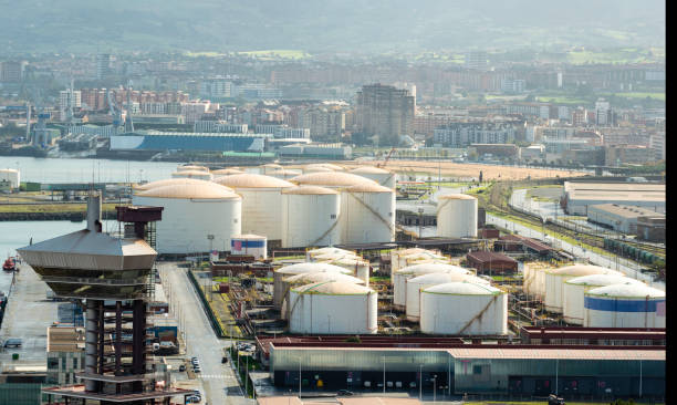Fuel and Oil Tanks in the Petrochemical Industry in daylight. City of Gijon at background. stock photo