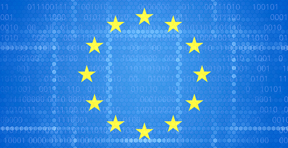 Human hand is inserting European Union flag into ballot box in front of black background. Representing elections in  European Union.