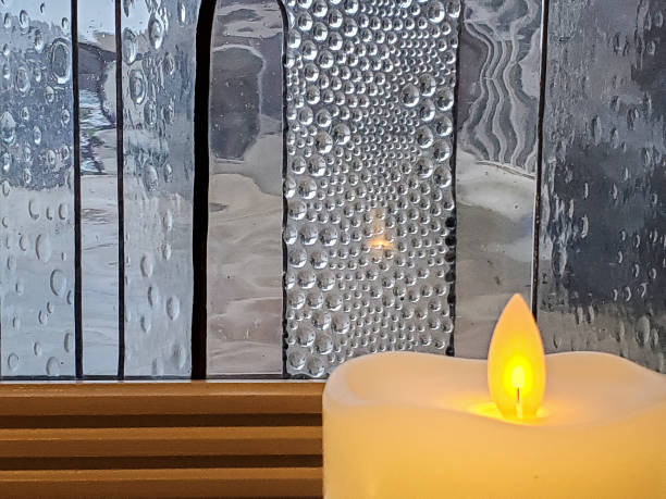 istock glowing candle by frosted window 1189231734