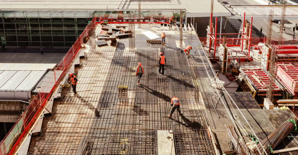 vista de ángulo alto de los trabajadores en el sitio de construcción - color image people built structure architecture fotografías e imágenes de stock