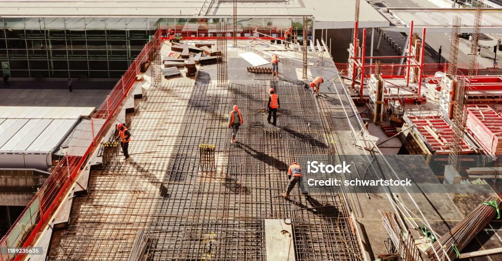 High angle view of workers in construction site Construction workers at a construction site viewed from above, High angle view of five people with helmets. Construction Site Stock Photo