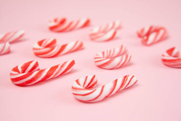 istock Striped peppermint sticks on pink background in perspective with shallow focus 1189240543