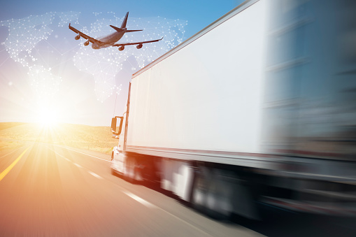 Cargo Truck and Airplane Moving Towards Delivery of Goods During Sunrise with World Map Background.