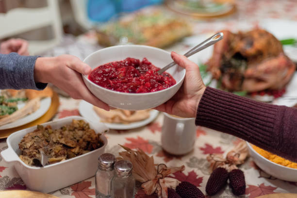 передача пищи во время праздничного приема пищи - cranberry sauce стоковые фото и изображения