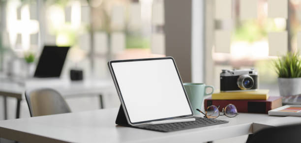 istock Close-up view of comfortable designer workplace with blank screen digital tablet, camera and office supplies 1189260778