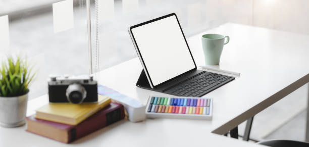 istock Cropped shot of modern graphic designer workplace with blank screen digital tablet, camera and office supplies 1189260783