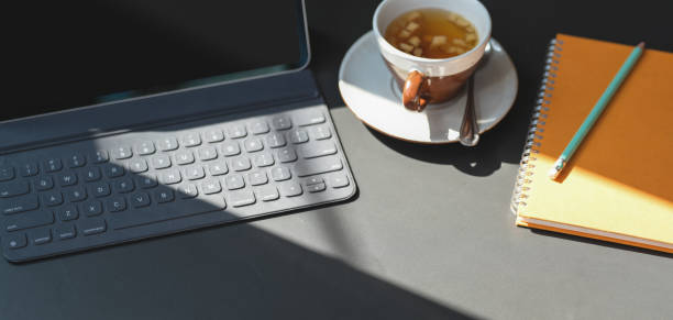 istock Cropped shot of modern workplace with tablet, notebook and a cup of tea 1189264272