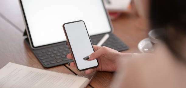 istock Close-up view of young businesswoman working on her project while using blank screen smartphone 1189264302