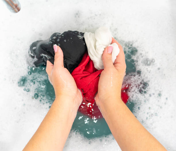 istock Red, black and white clothes in basin with detergent foam 1189265305