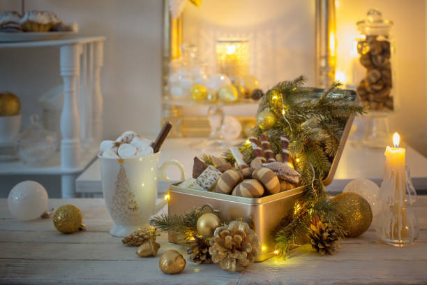 istock Christmas sweets in golden box and cocoa mug with marshmallows on a white table 1189267863