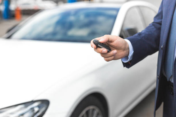 istock Male holding car keys with car on background 1189282177