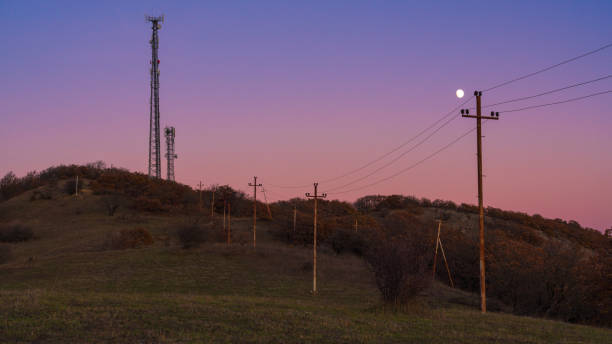 сотовая антенна на холме в вечернее время - moody sky audio стоковые фото и изображения