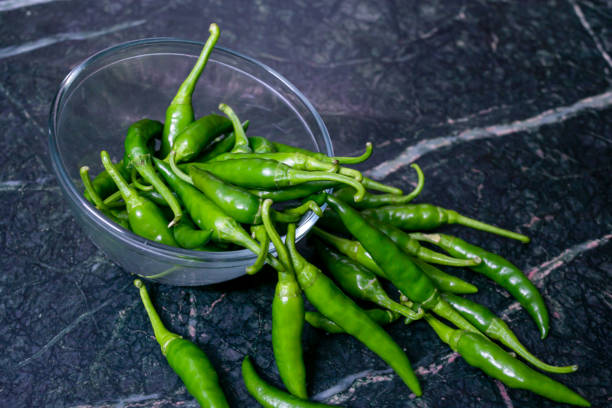 istock Fresh harvested green chili in a bowl on texture background. 1189285665