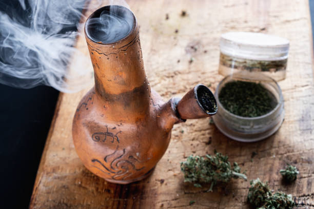 istock Old bong and open cannabis grinder with chopped weed and marijuana in smoke 1189293379