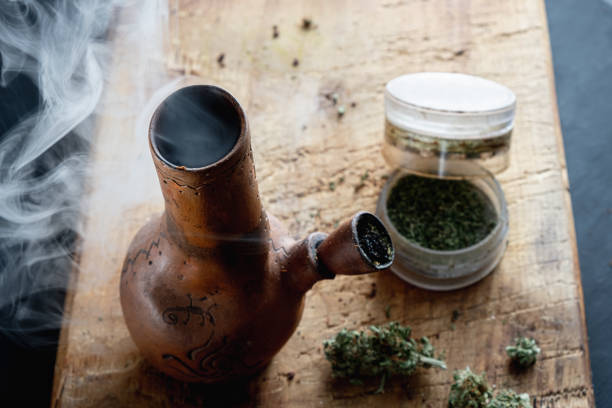 istock Old bong and open cannabis grinder with chopped weed and marijuana in smoke 1189293421