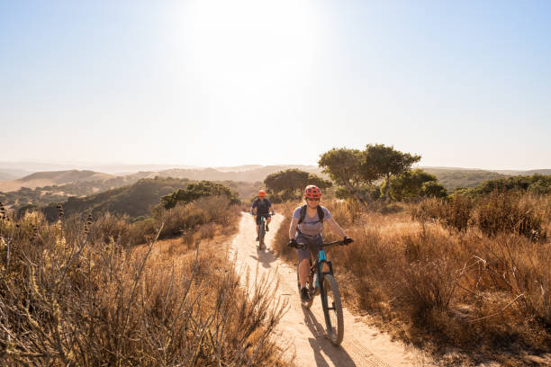 femme et homme explorant le sentier simple de voie sur des vélos de montagne - recreational pursuit mountain biking nature outdoors photos et images de collection