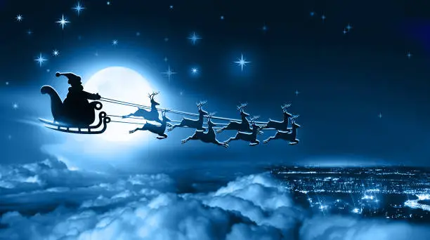 Photo of Winter christmas night. Santa Claus in a sleigh flies over Earth on background of full moon