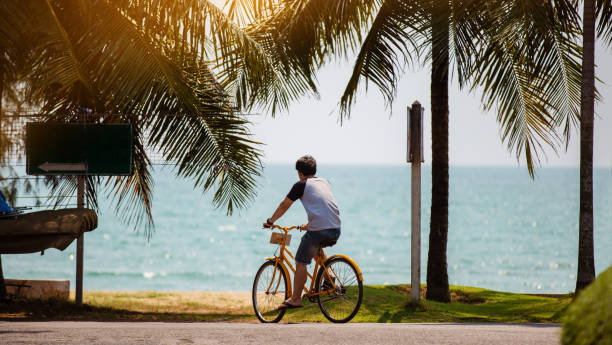 istock Asian men riding bicycles on the beach 1189299449