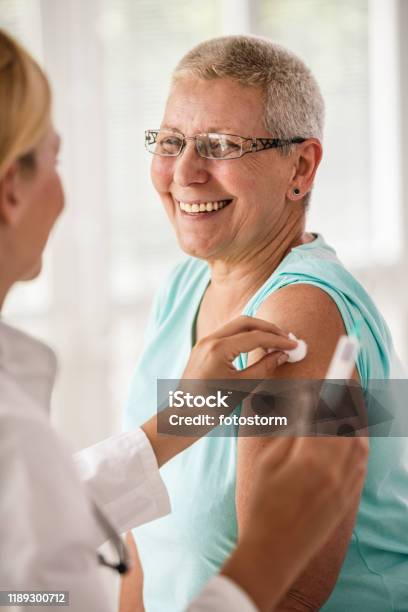 Doctor Disinfecting Patients Arm Before Vaccination Stock Photo - Download Image Now