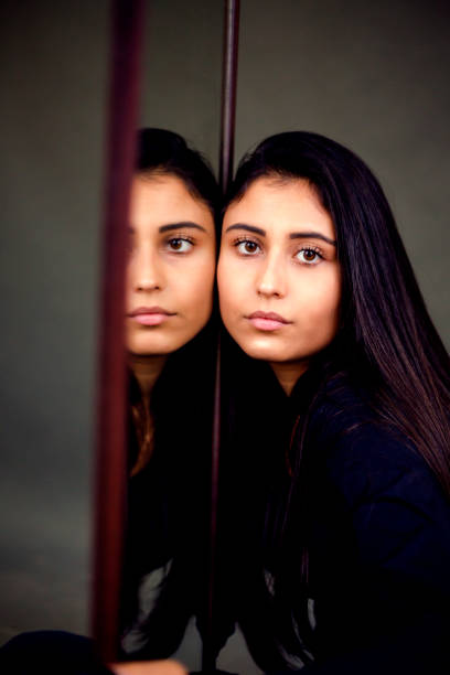 istock Beautiful young female brunette model look her self in the mirror 1189301705