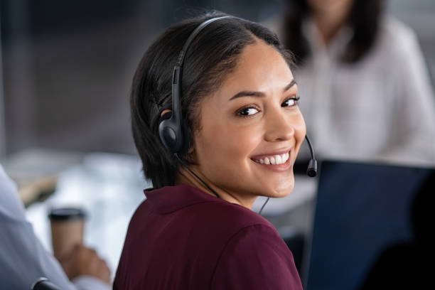 femme utilisant le casque dans le centre d'appel - receptionist customer service customer service representative photos et images de collection