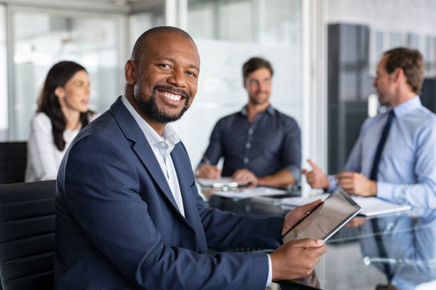 hombre de negocios africano maduro en la reunión - board room group of people business person clothing fotografías e imágenes de stock