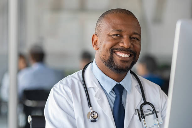 felice sorridente medico nero guardando la macchina fotografica - doctors office doctor research healthcare and medicine foto e immagini stock