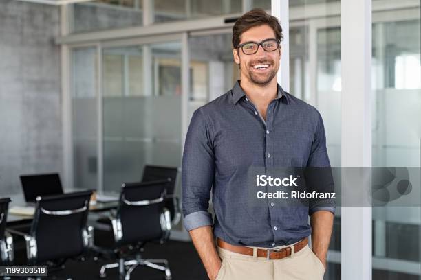 Empresario De Éxito Sonriendo En La Oficina Foto de stock y más banco de imágenes de Hombres - Hombres, Ejecutivo, Oficina