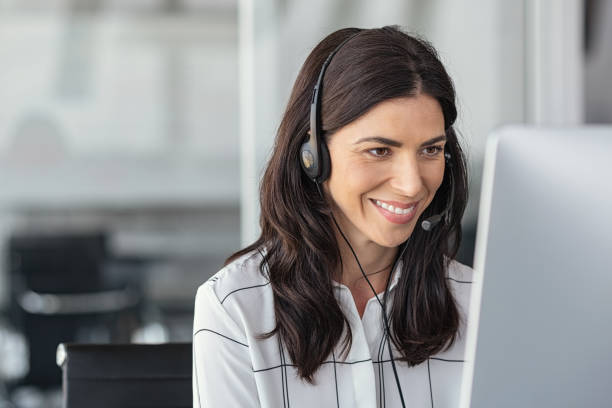 smiling latin woman in call center - bluetooth headset women customer imagens e fotografias de stock