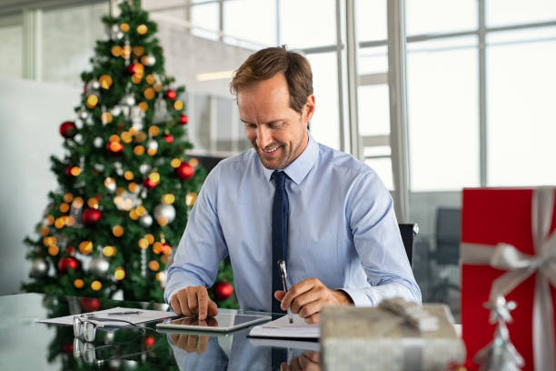 istock Businessman working on digital tablet at christmas 1189303634