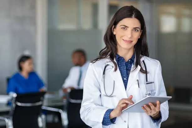 Photo of Doctor holding digital tablet at meeting room