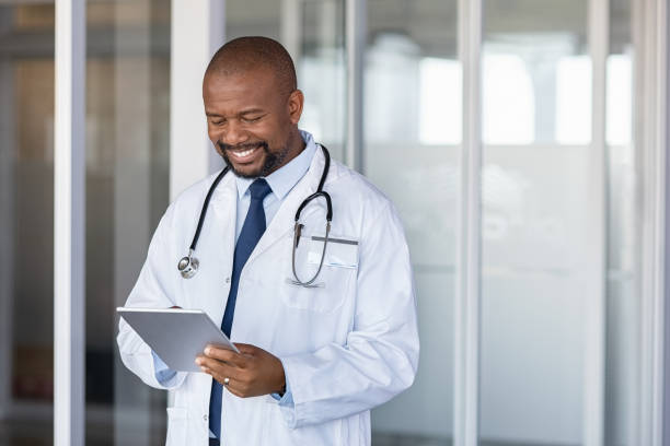 African doctor using digital tablet at hospital