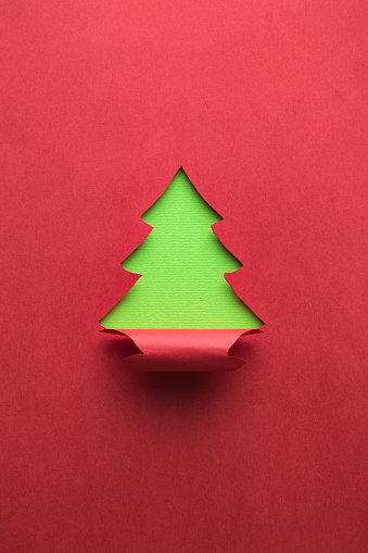 Christmas tree made of green and red paper. New year abstract.