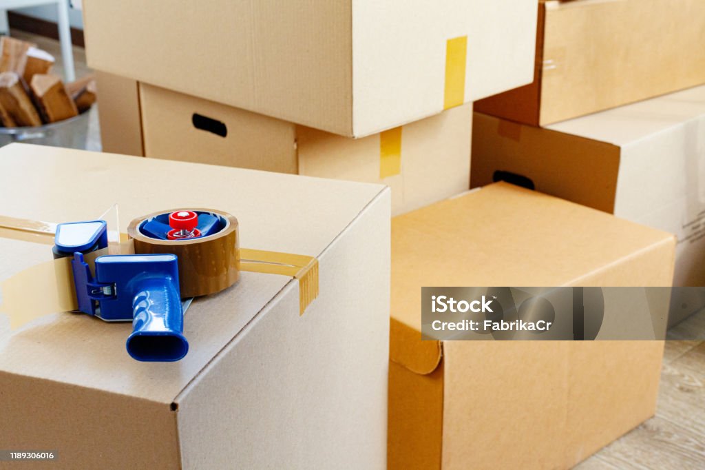 House moving concept with stacked cardboard boxes in a room Relocation Stock Photo