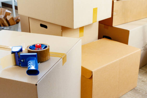 House moving concept with stacked cardboard boxes in a room stock photo