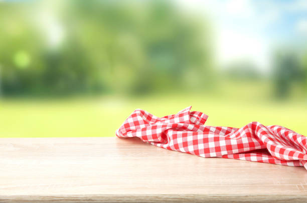 istock Red checkered picnic cloth on wooden table empty space background. 1189309576