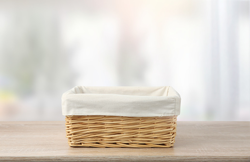 Straw emprty basket decorated with white linen on wooden table,food advertisement template.Container.Wicker.