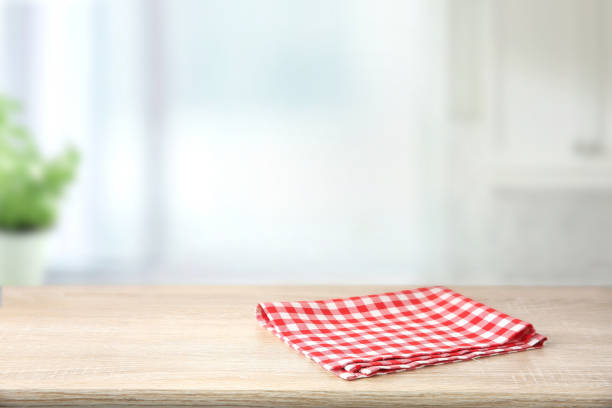 istock Red checkered folded picnic cloth on wooden table empty space background. 1189309839