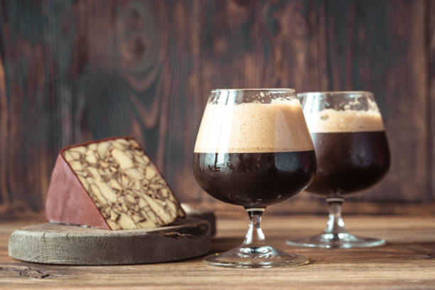 Two glasses of dark beer with Irish Porter Cheddar Two glasses of dark beer with Irish Porter Cheddar porter photos stock pictures, royalty-free photos & images
