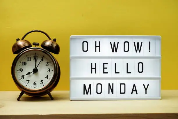 Hello Monday text in lightbox with alarm clock on Yellow background