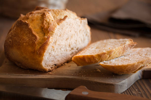 istock Sliced loaf of wheat bread on wooden table 1189314786