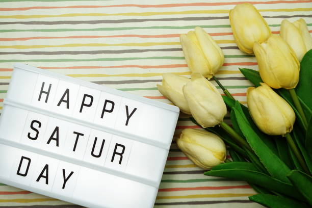 istock Top view Happy Saturday Text in Light box flat lay with tulip flower bouquet 1189314971