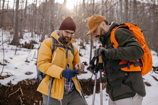 istock Male hikers using mobile phone on winter hiking tour 1189318821