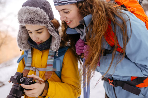 istock Mother with son checking photos on camera during winter vacation 1189318843